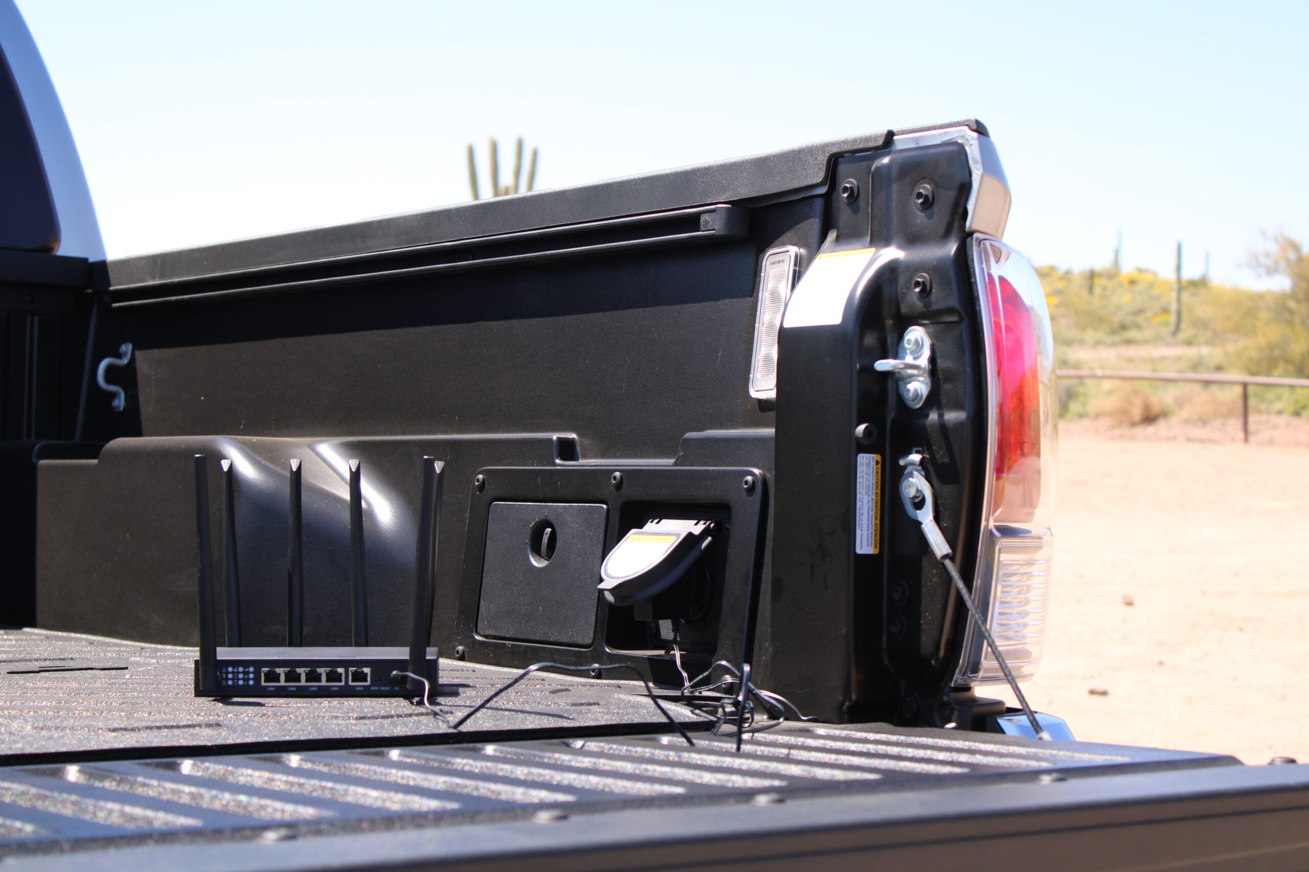X-LINK router mounted in a pickup truck bed with desert landscape in background.
