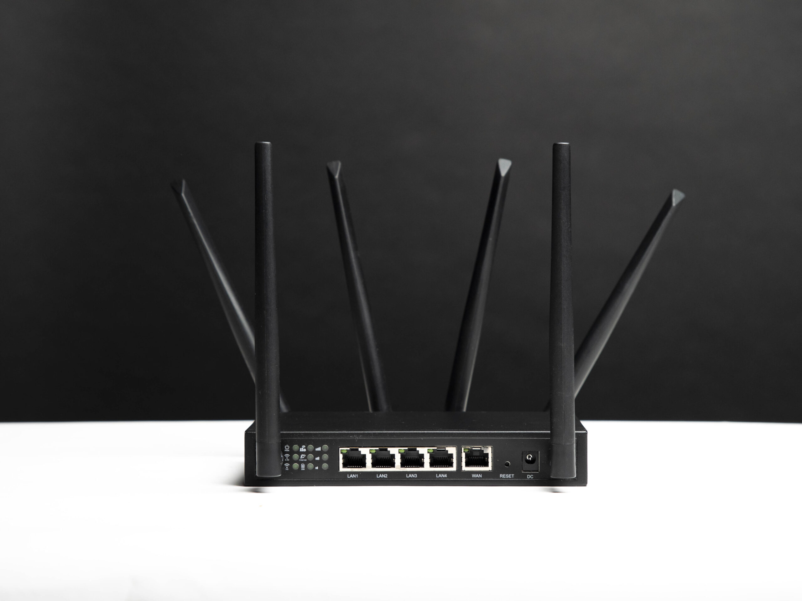 Rear view of the X-LINK router showing its antennas and Ethernet ports on a black background.